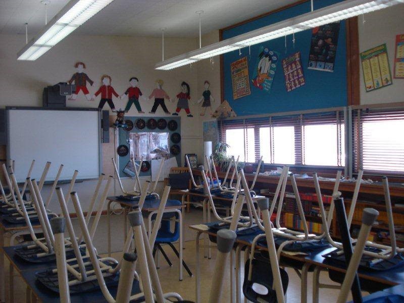 Photo of a classroom with chairs on the desks.