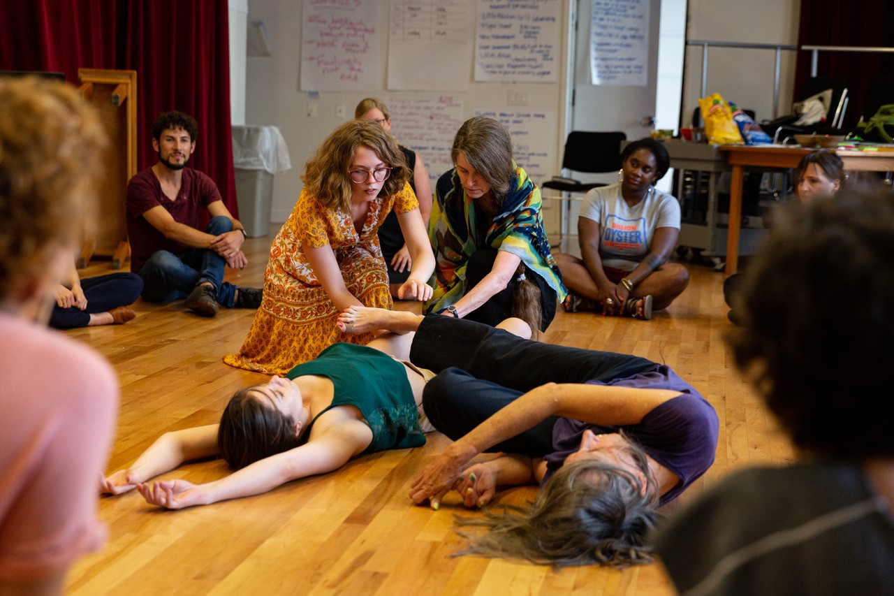 Acting class with students on the floor.